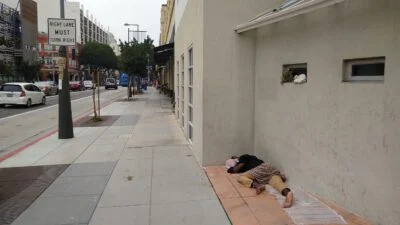 Homeless sleeping next to the street